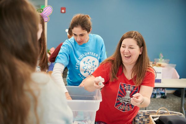 Volunteers organizing art supplies in bins